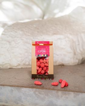 sachet de pralines roses devant une sculpture